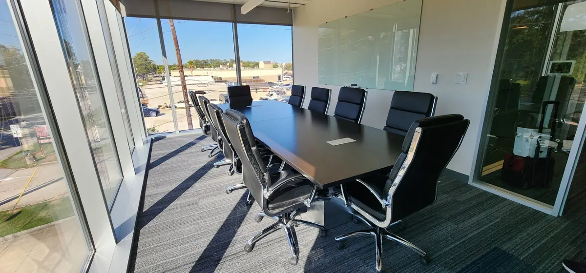12-seat boardroom table with black leather chairs