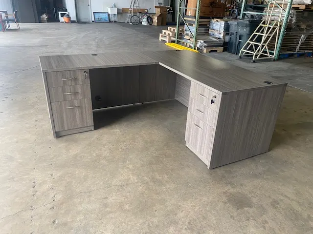 Office desk staged on the New Space warehouse floor after removal
