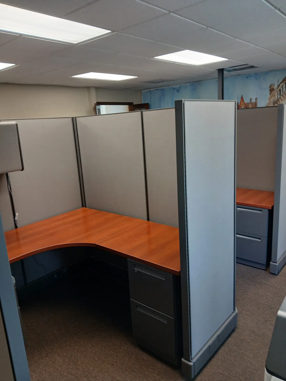Corner cubicle workstation with wood-tone surface and mobile pedestal, Conroe