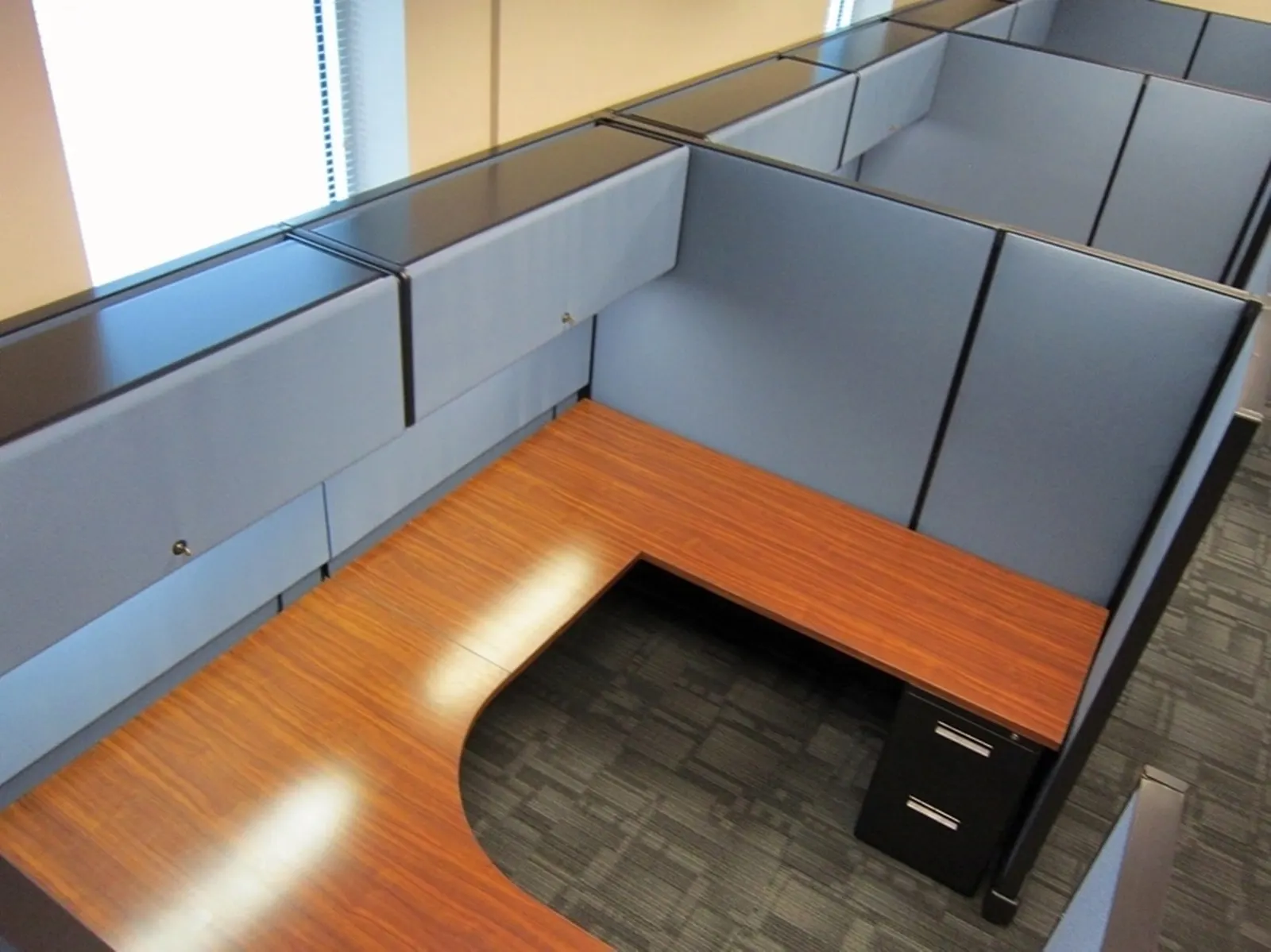 U-shaped Herman Miller AO2 cubicle with cherry work surfaces and overhead storage
