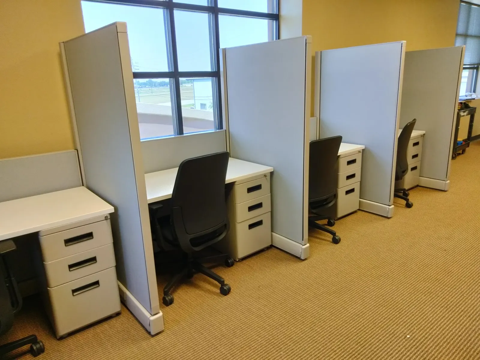 Workstation floor laid out per space plan with panel-mounted desks and mobile pedestals