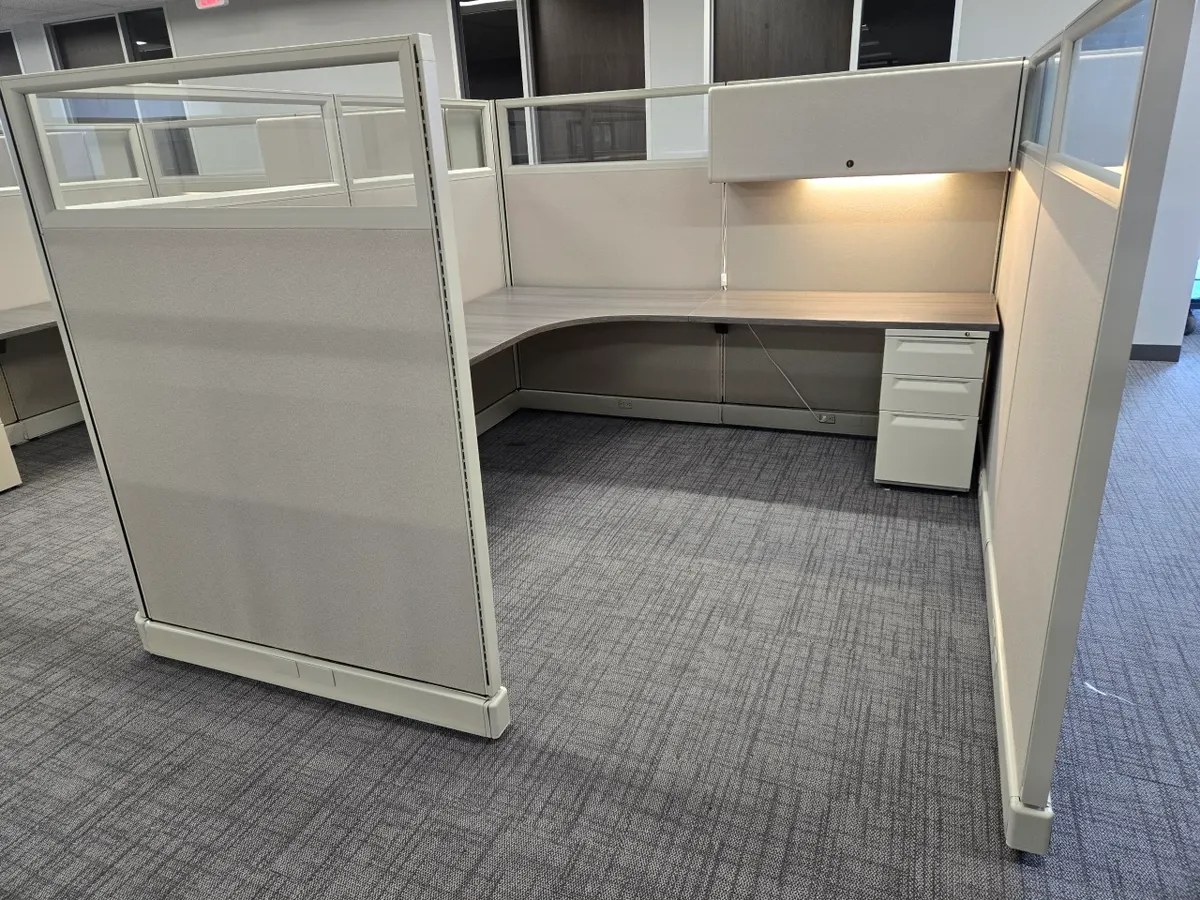 Glass-top cubicle run along an office corridor
