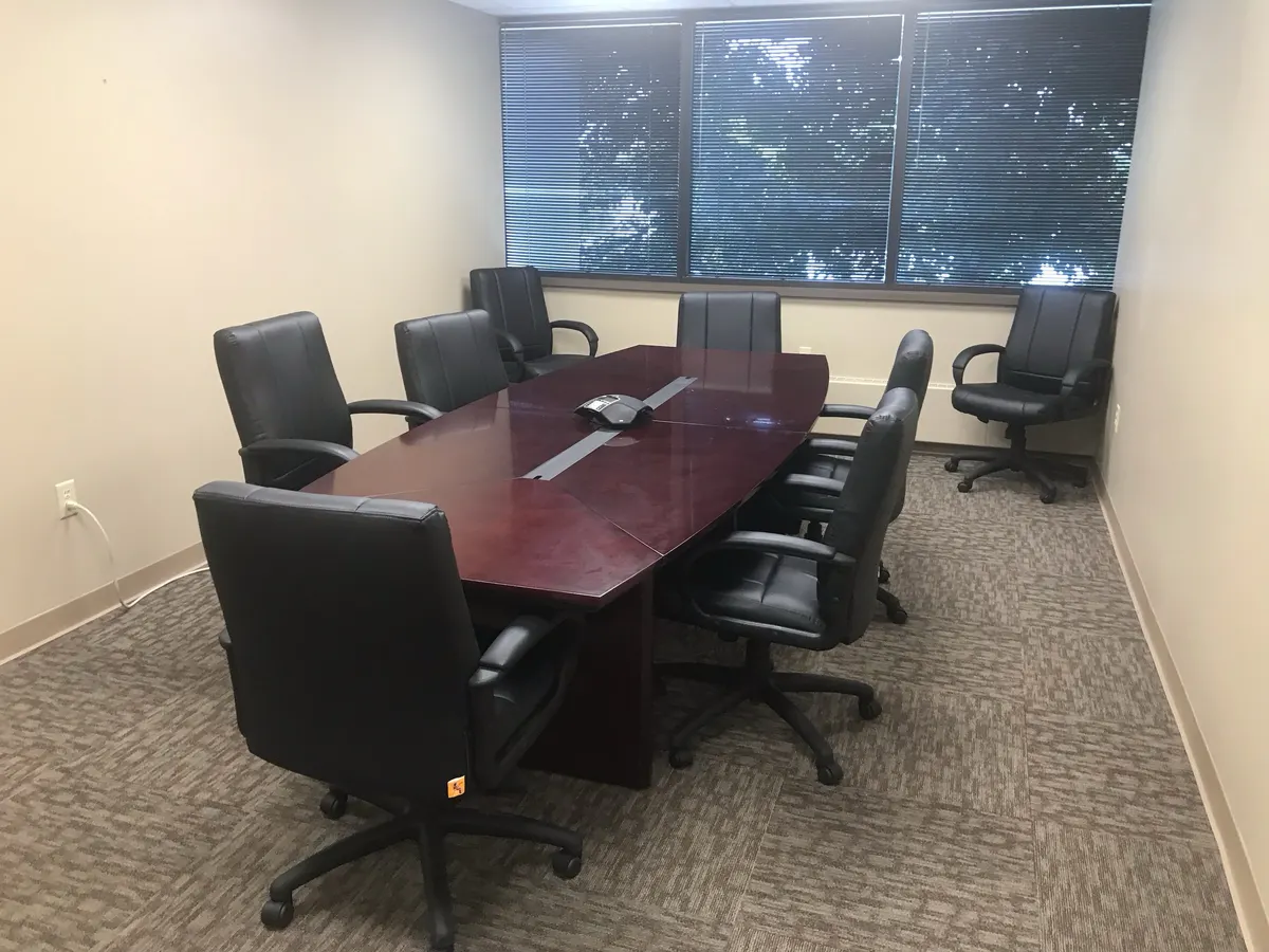 Mahogany conference table with executive chairs by a window