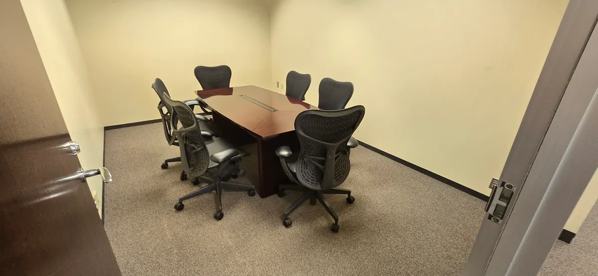 Six-foot conference table with mesh task chairs