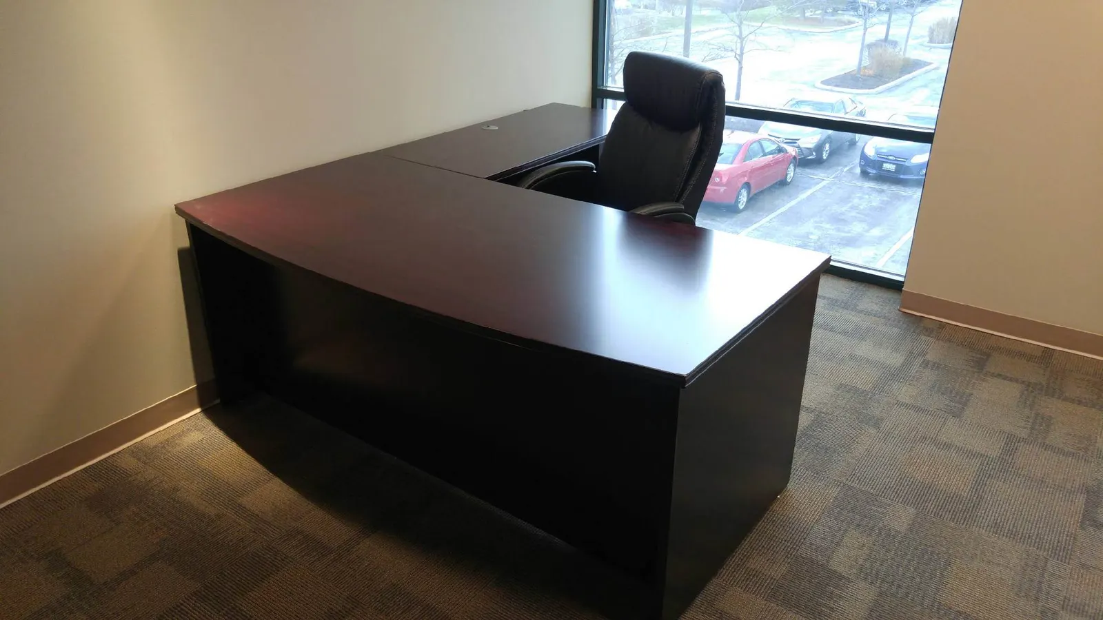 Executive private office with mahogany U-shaped desk and window view