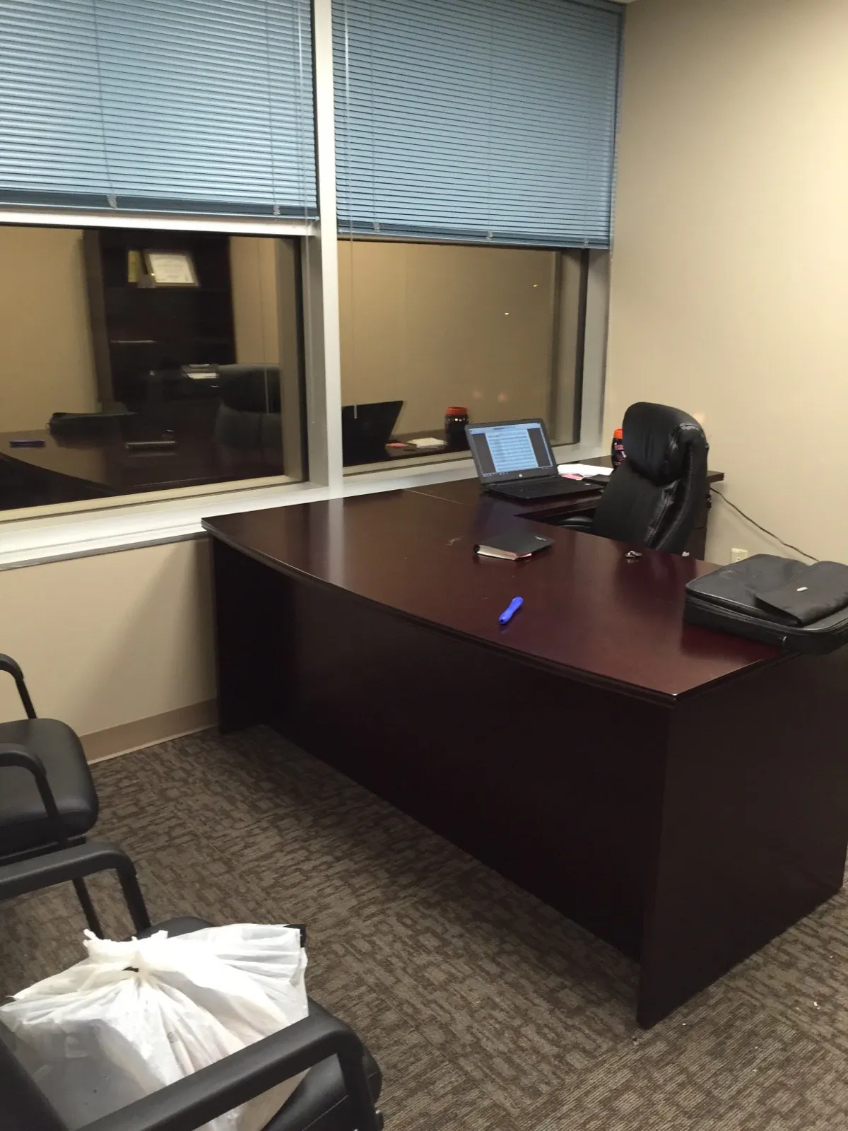 Compact private office with mahogany desk and window view